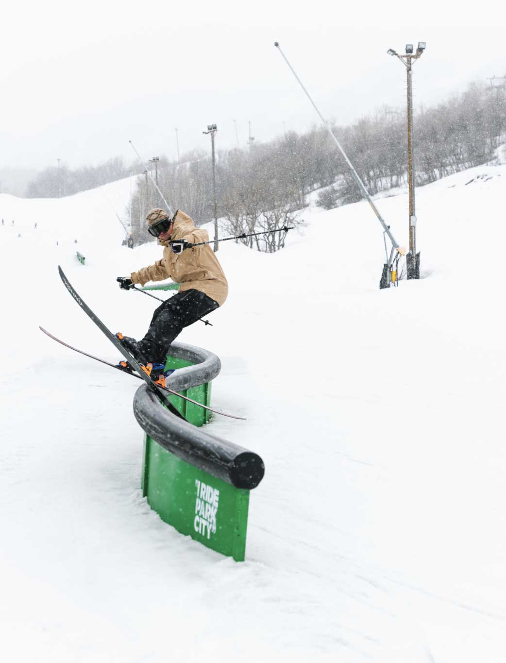 Man slides rail wear a baggy snowboard jacket