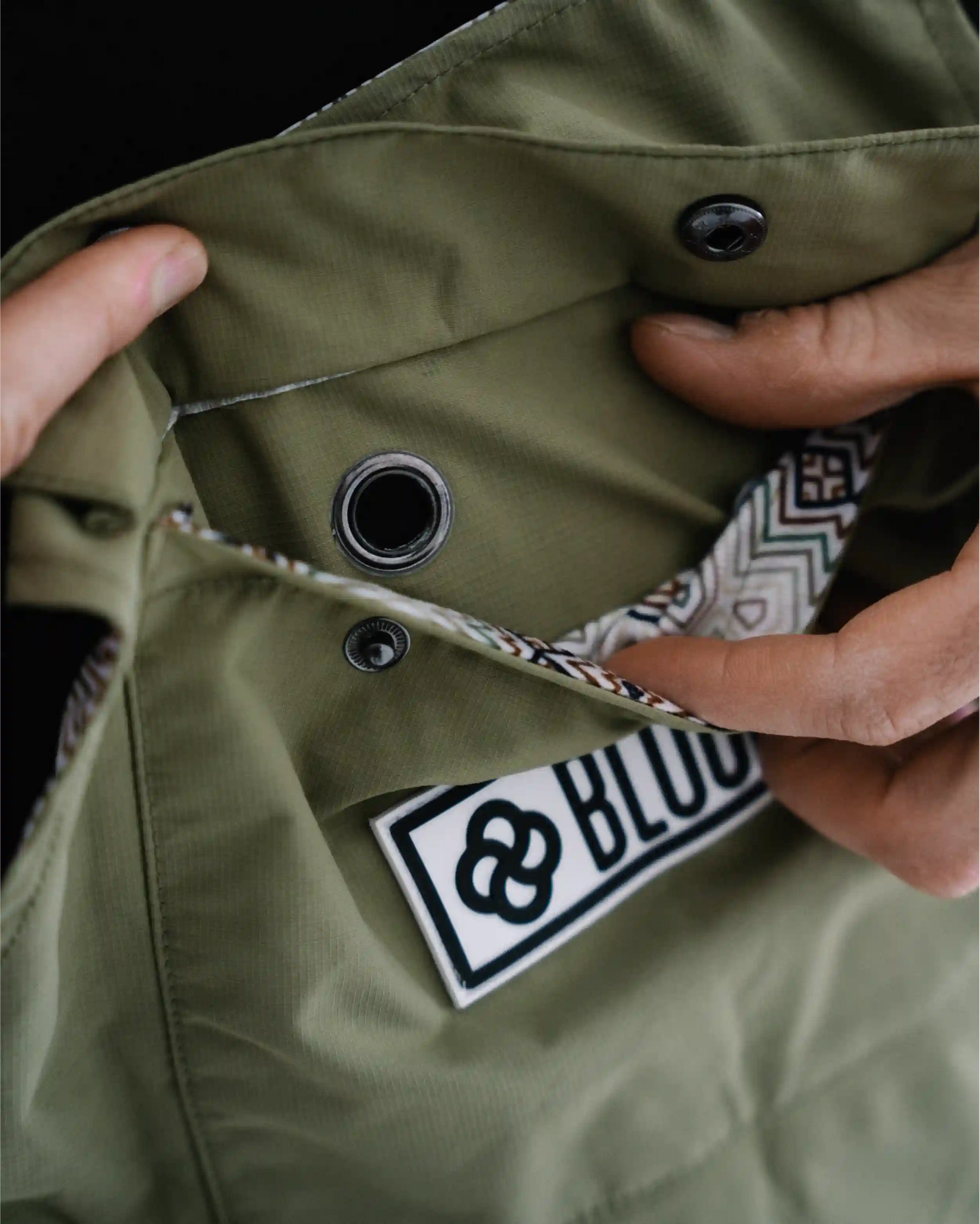 Close up of a phone pocket with wire feed through on the best ski bibs