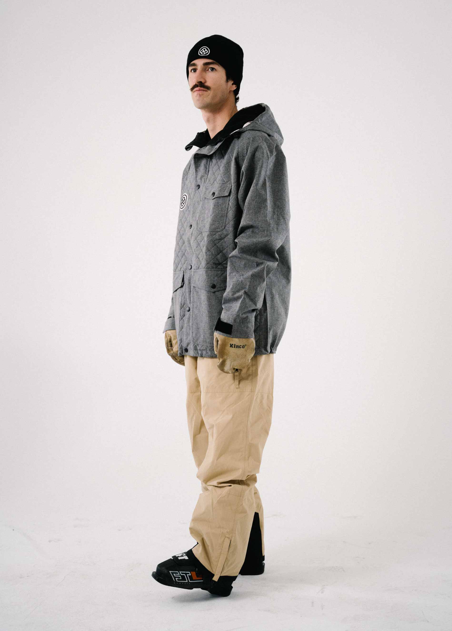 Cool skier wearing men's gray ski jacket and khaki bib ski pants