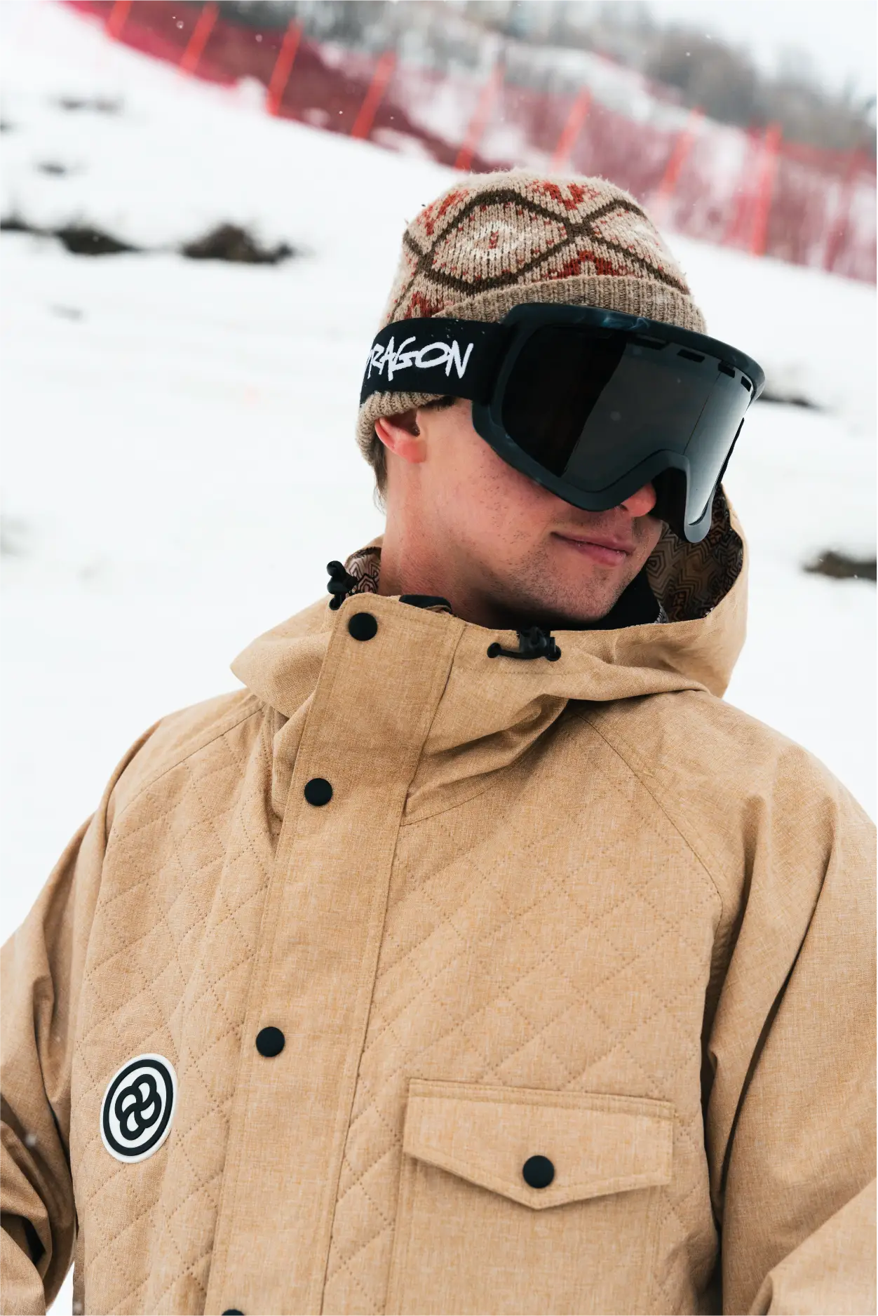 Man wearing quilted ski and snowboard jacket in a snowy setting
