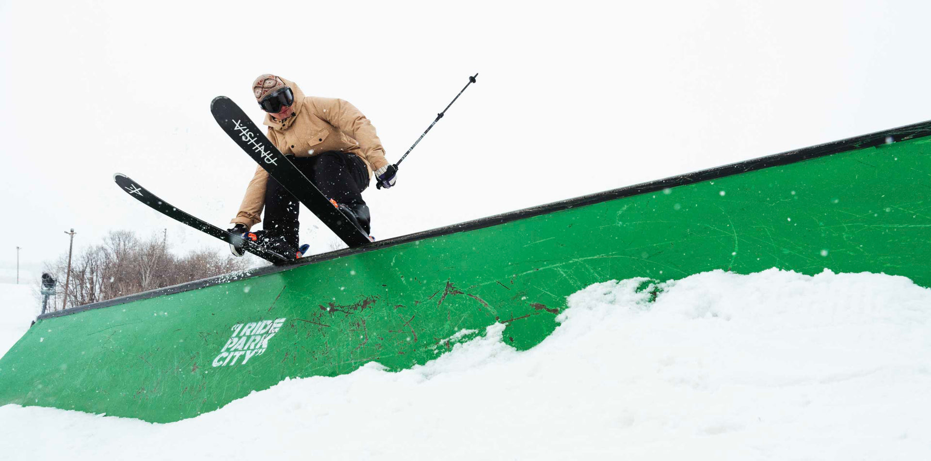 Skier slides a rail wearing a baggy ski jacket