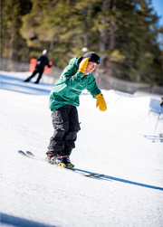 Park skier wearing a black baggy ski bib while skiing downhill
