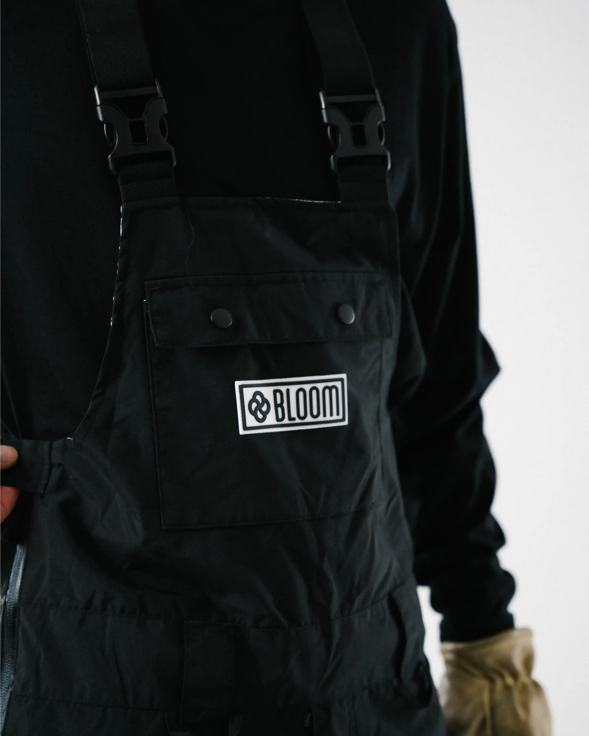 Phone pocket with button closure on black baggy snow pant