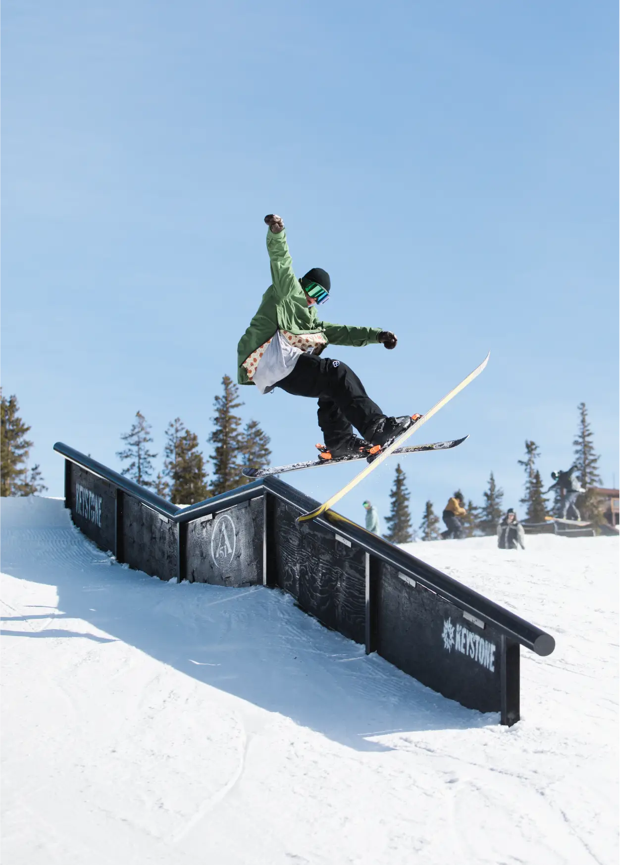 man skiing down slope in black baggy snow pant