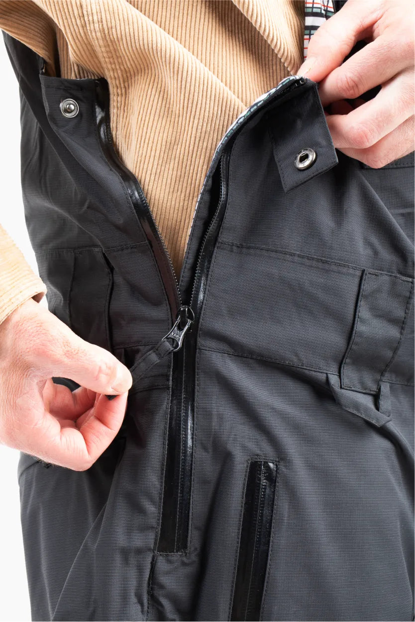 Close up of a black ski bib with side entry zipper