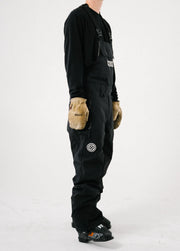 Side studio view of a men's black ski bib