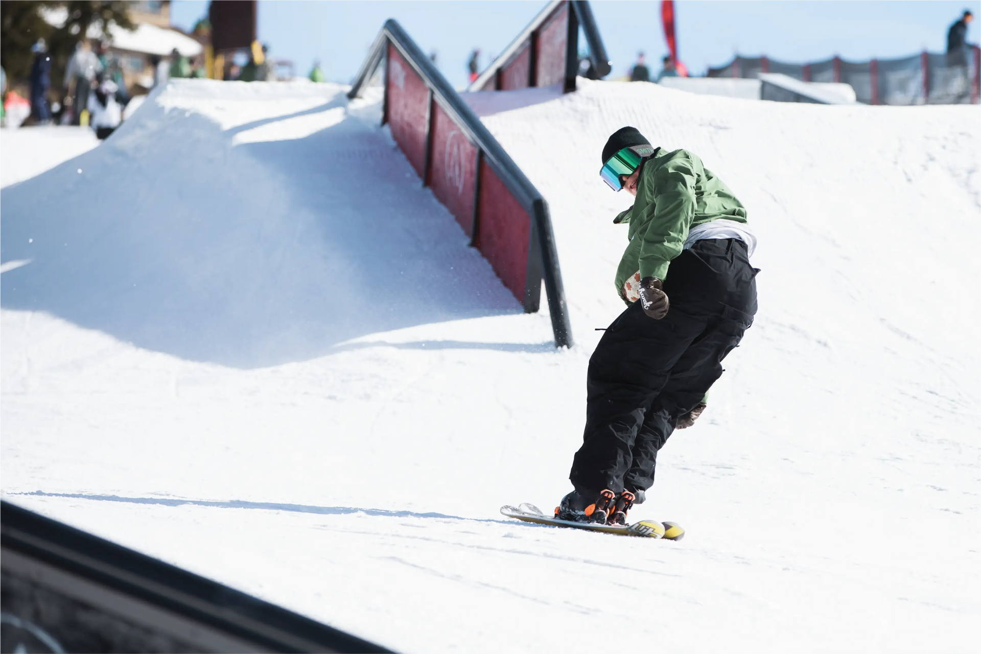 Man skiing backwards in park wearing baggy black ski pants