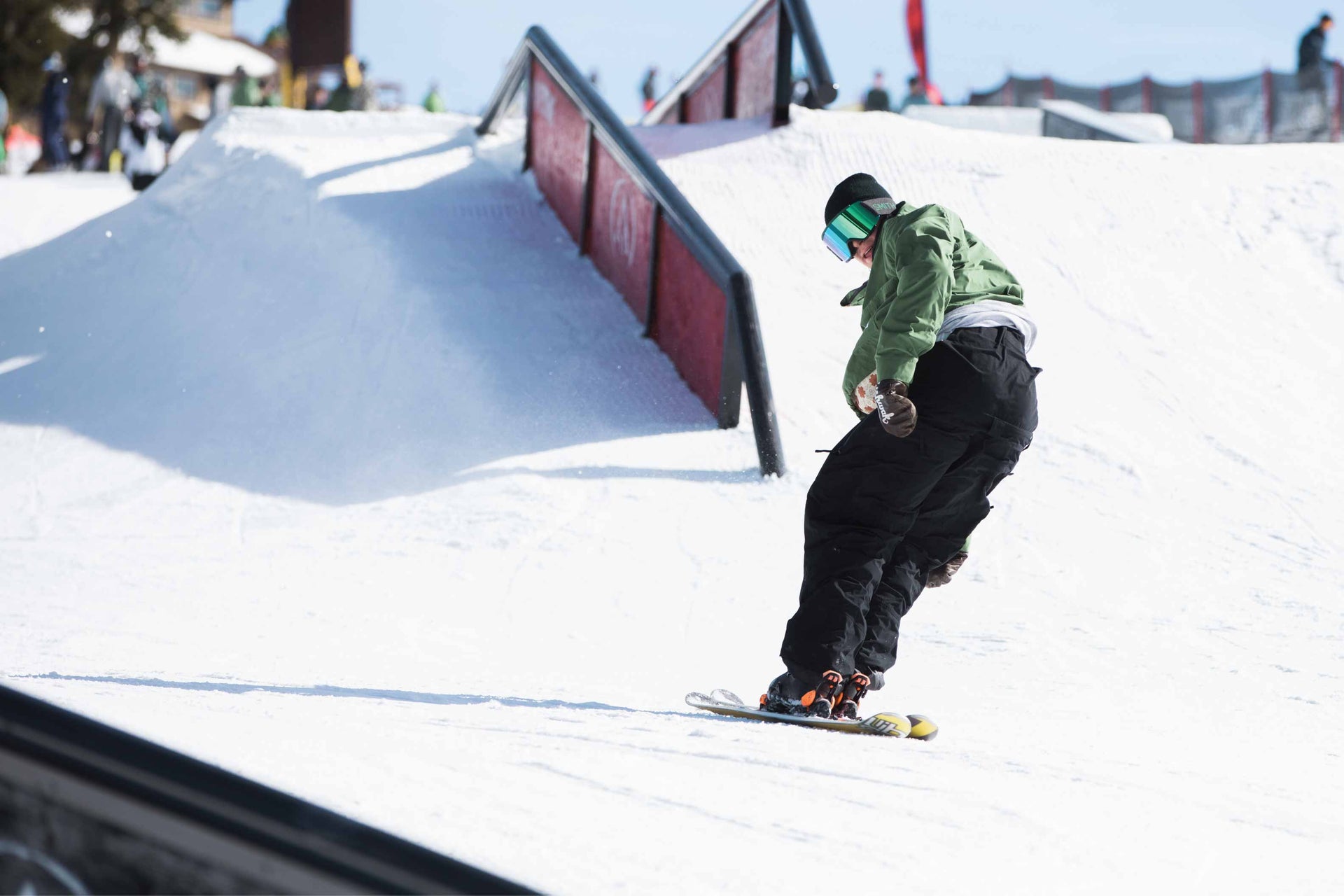 Man skiing down slope in park backwards wearing cool baggy snowboard pants