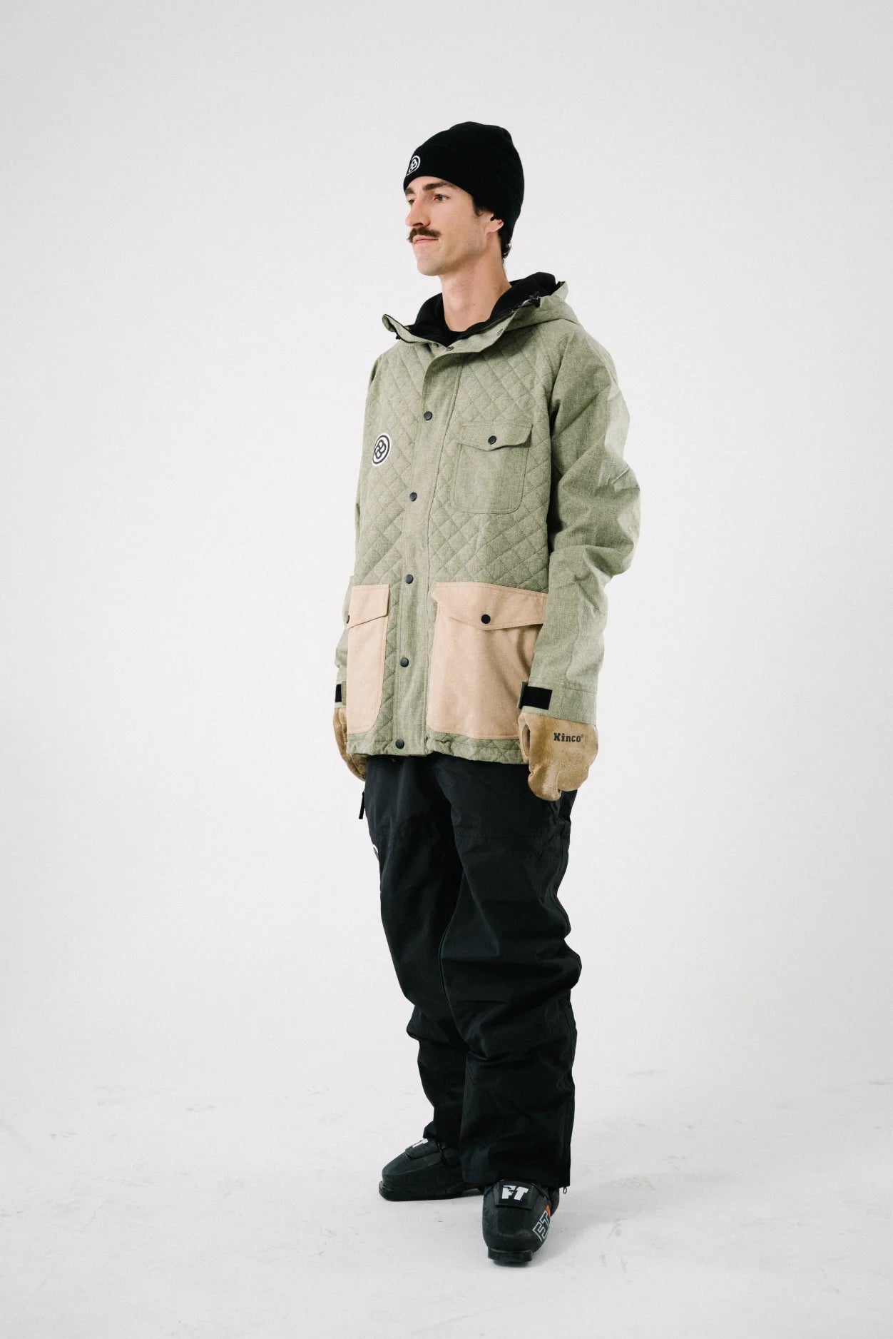 Man wearing a green quilted snowboard jacket