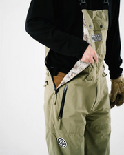 Close up of men's green ski bib shell side zipper