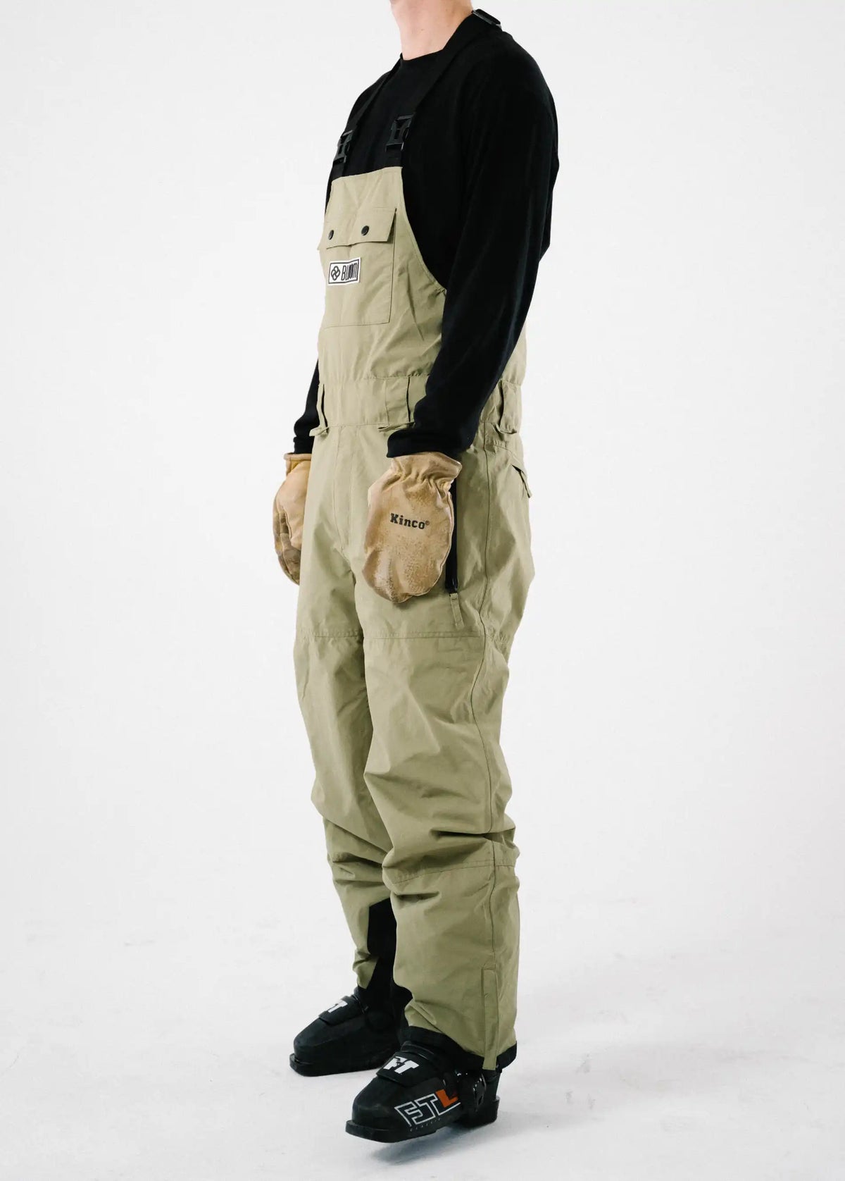 Side view of a men's green ski bib shell