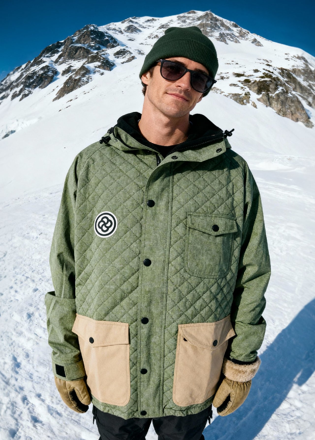 Man wearing green ski jacket in mountain setting