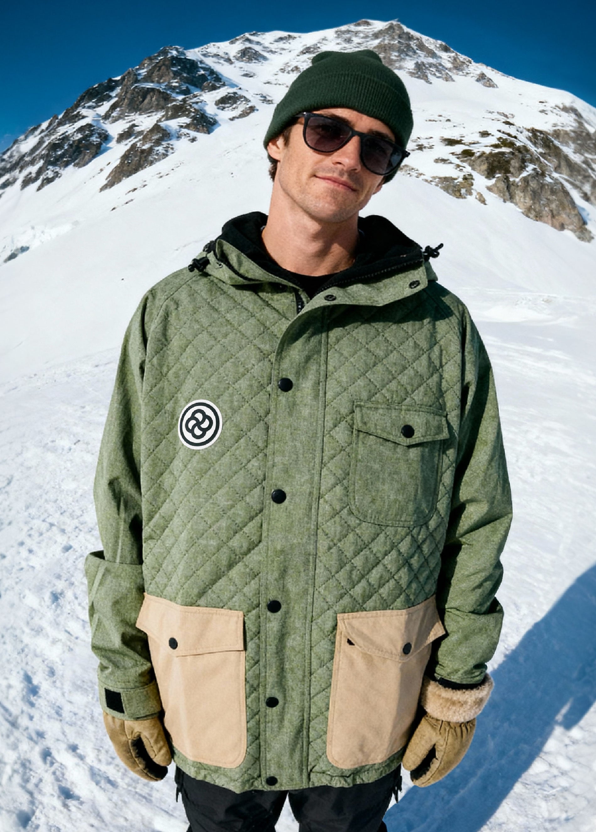 Man wearing green ski jacket in mountain setting