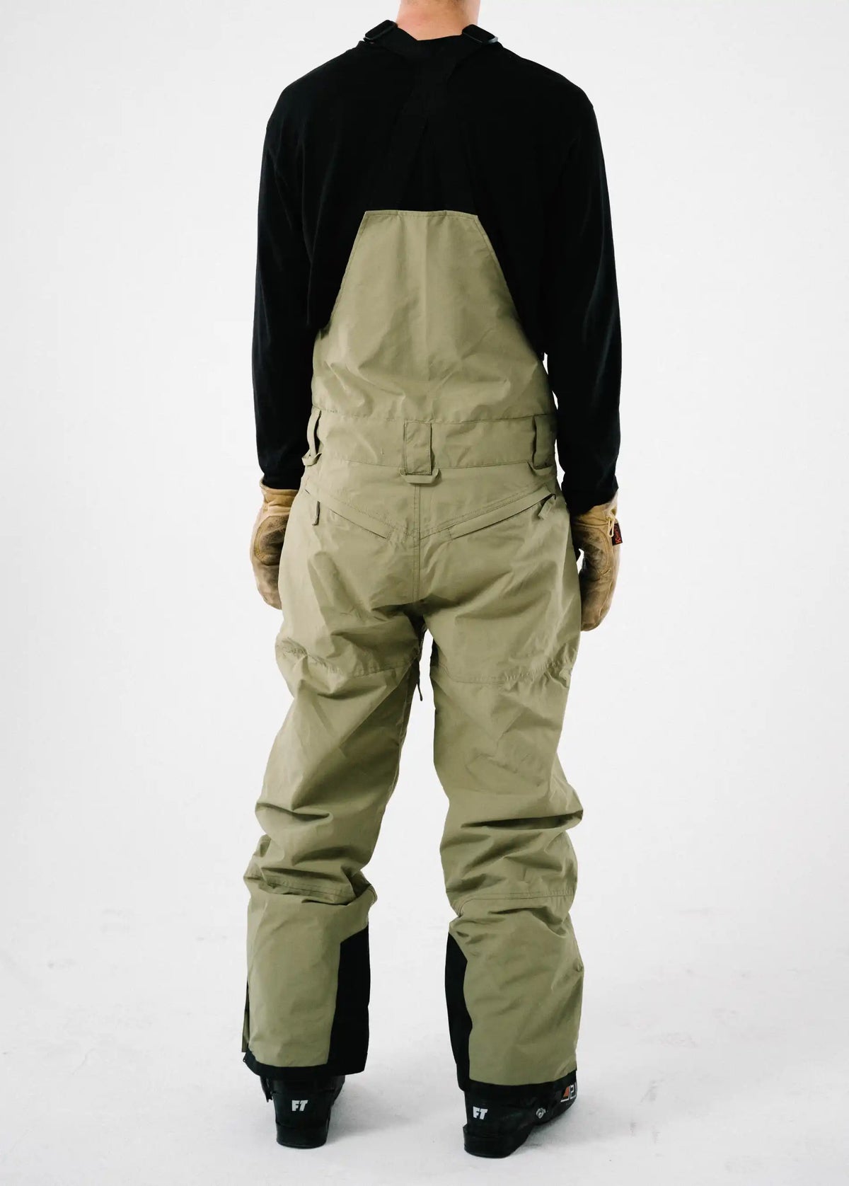 Back view of a men's green ski bib shell