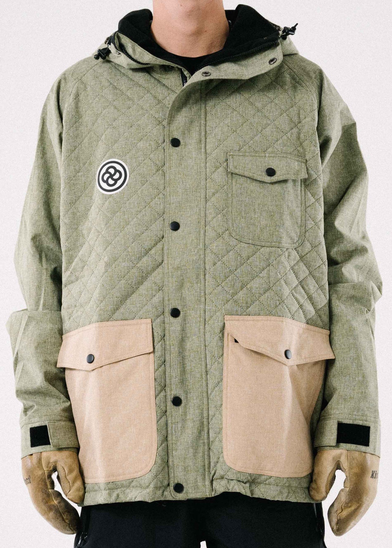 Insulated green ski jacket  with quilted pattern against a white backdrop
