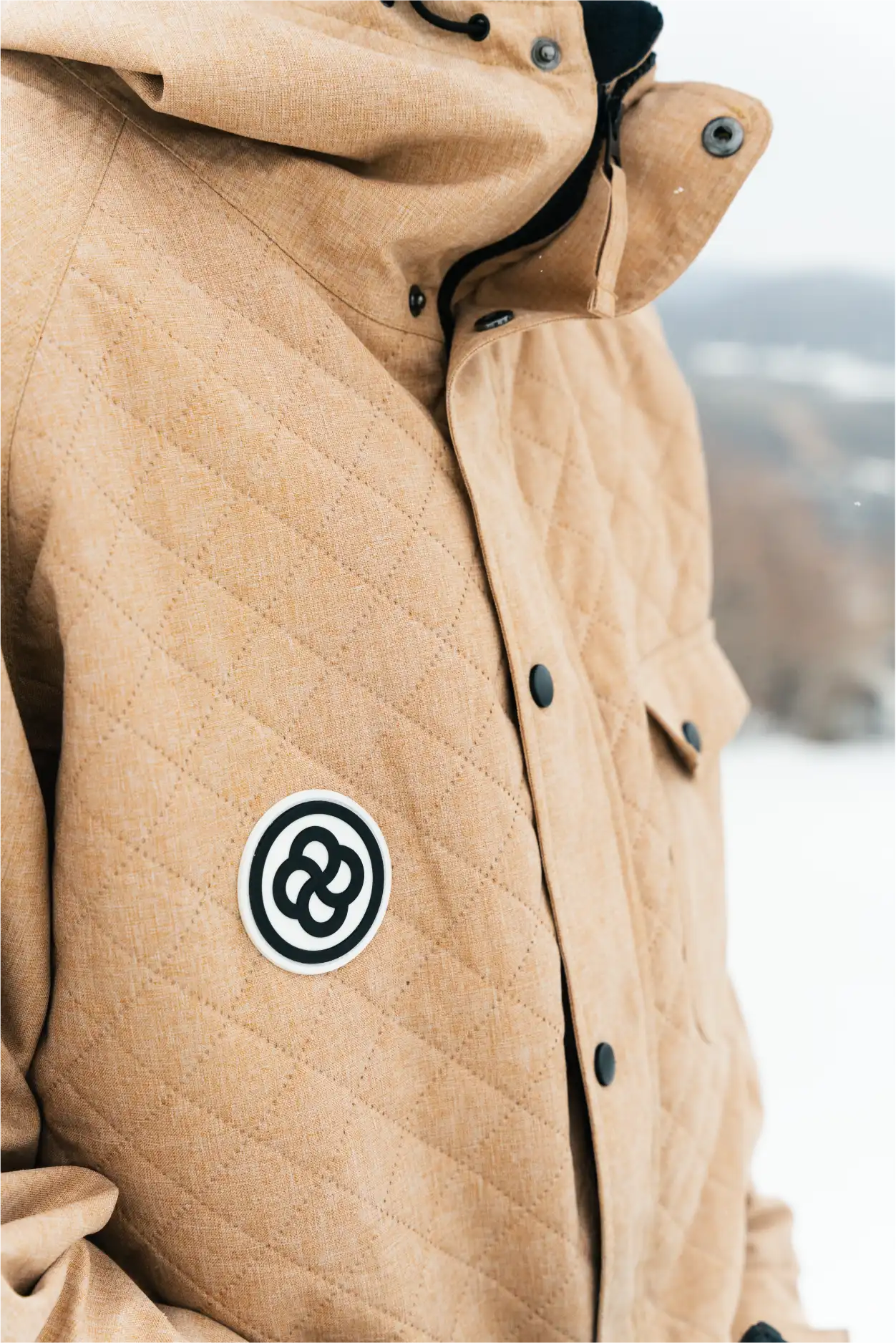 A tan quilted ski and snowboard jacket