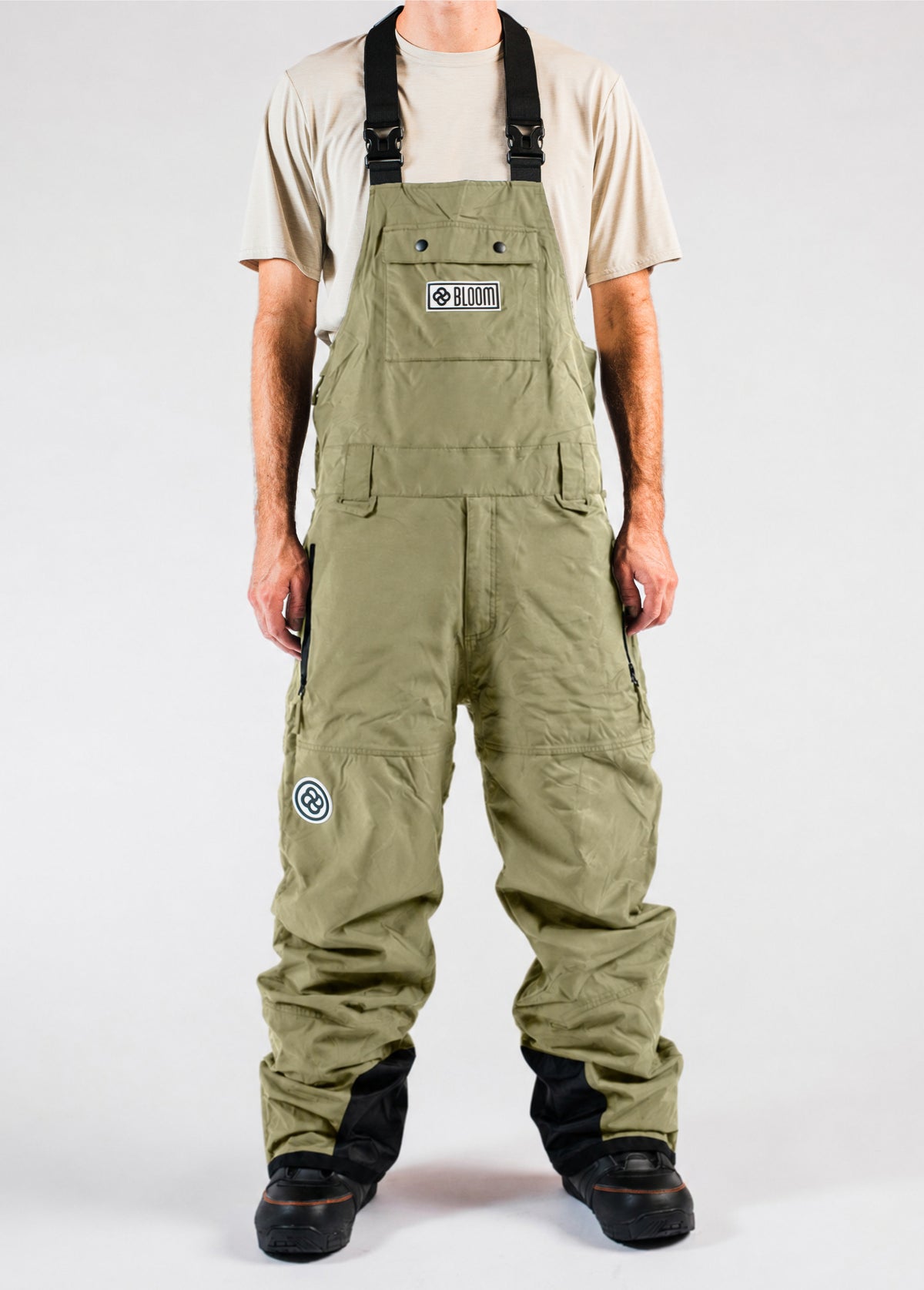 Men’s green shell snowboard bib pants with a baggy fit and adjustable suspenders.