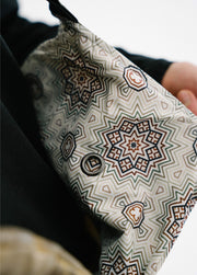Close-up of the men’s green Bloom Rove snowboard bib showing its sublimated geometric-print interior lining.