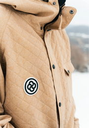 A tan quilted ski jacket with black buttons